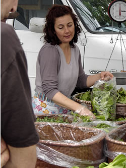 From field to customer, Charuth Loth bags mixed greens, farmer's market. (Tom Lynch)