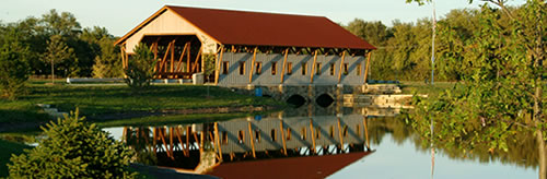 Numerous bridges on the roads and hiking-biking paths&mdash;including this covered bridge at the entrance&mdash;are a highlight of the Bridges community. (The Bridges) 