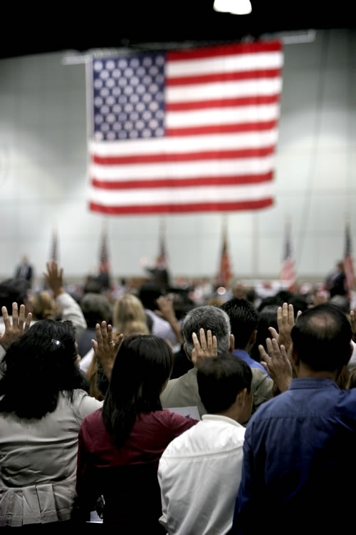 New immigrants taking the oath to become U.S. citizens at a public ceremony. (P_Wei/iStockPhoto.com)